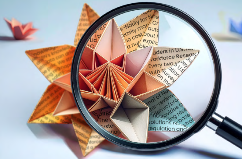 Close-up of a magnifying glass focusing on a detailed origami star made from folded newspaper and colored paper.